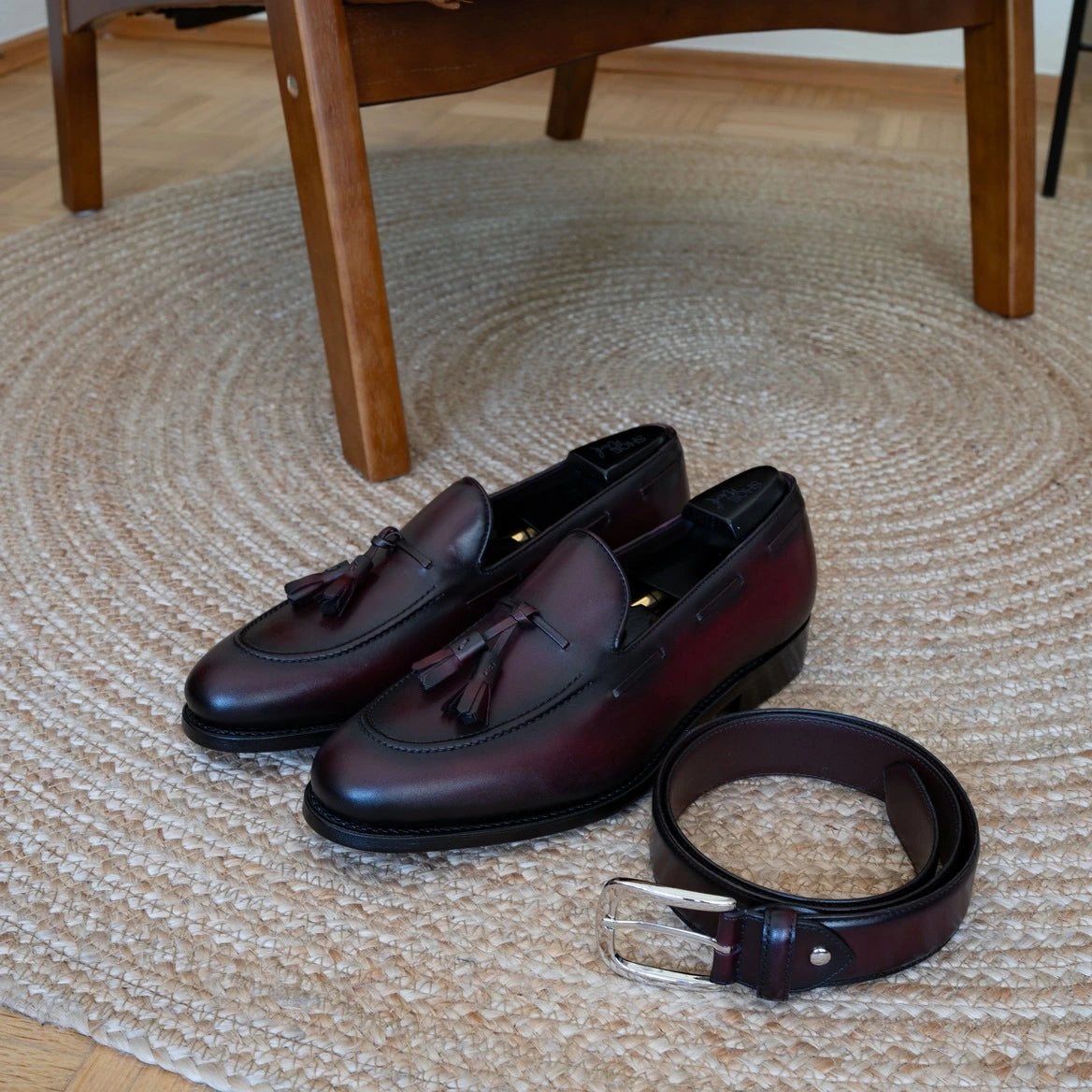 loafer Schuh abgelichtet mit einem Gürtel auf dem Teppich. Bild platziert auf der Startseite von shoeWerk